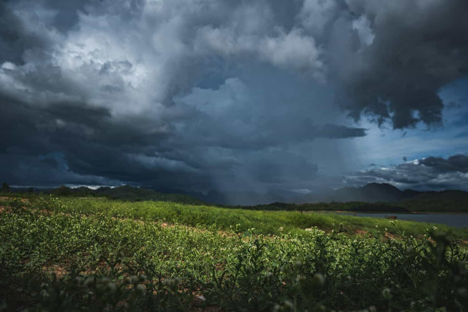 cielo tempestoso con nuvole e ambiente scuro sopra lo stagno e il lago circondato dal verde e senza persone