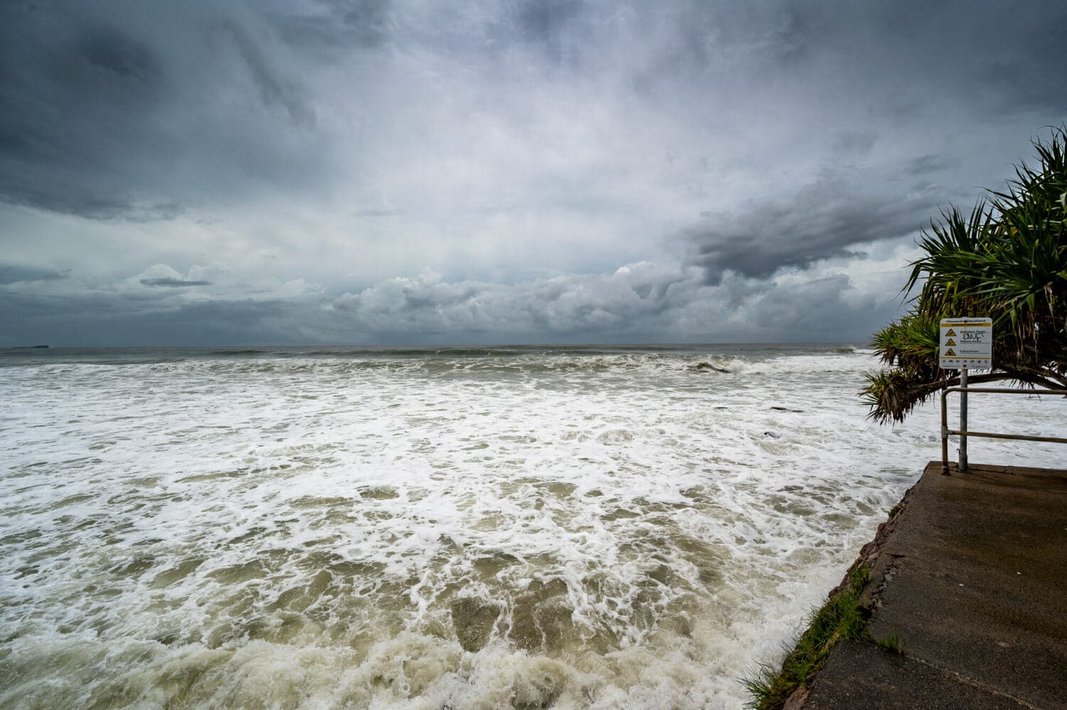 dolore schiumoso sotto il cielo nuvoloso scuro in alexandra headland beach queensland australia
