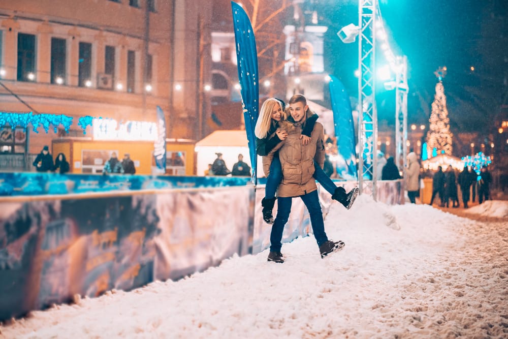cheerful playful couple warm winter outfits are fooling around