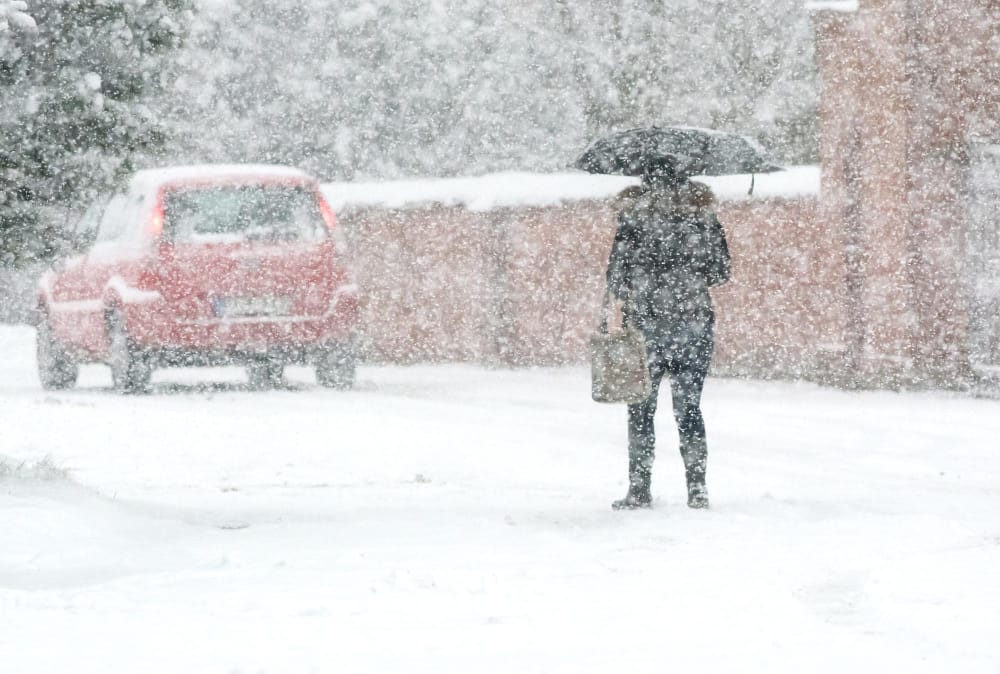 la gente cammina lungo la strada innevata