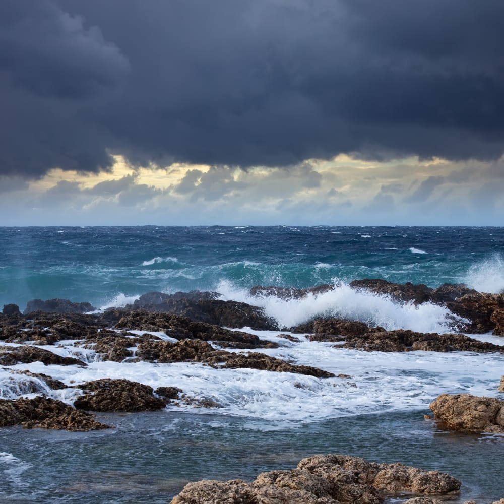 onda di mare che rompe contro la roccia della costa