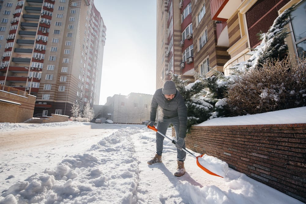 young man clears snow front house sunny frosty day cleaning street from snow