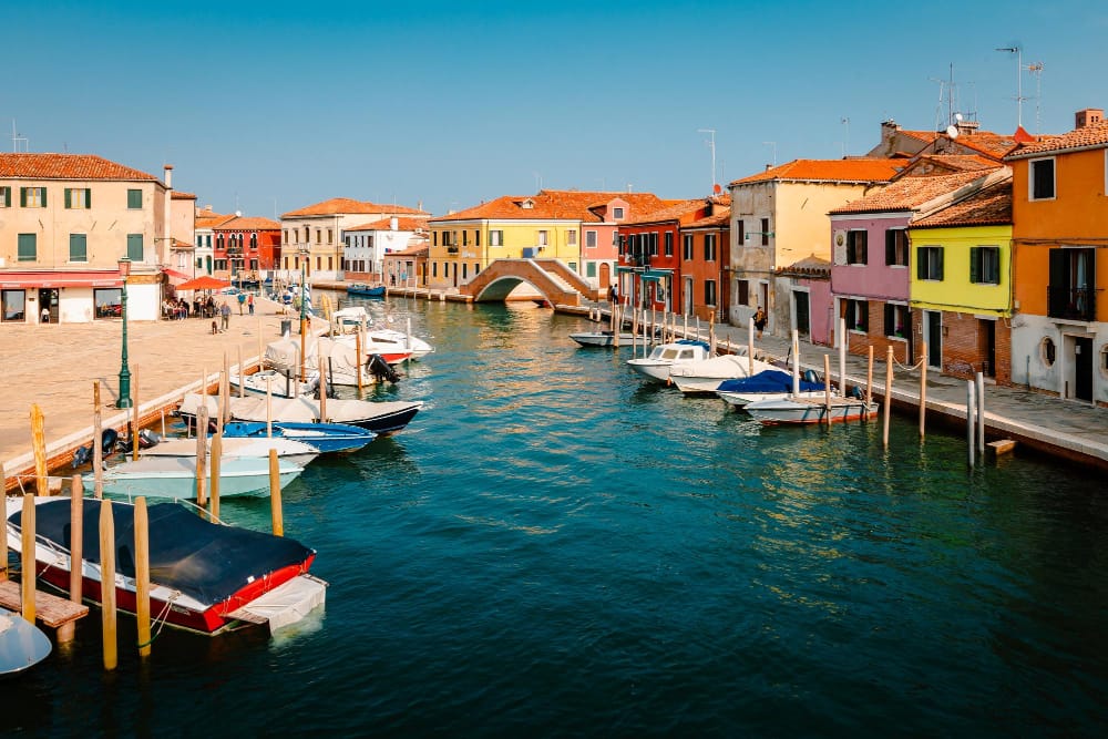 tipico canale di murano con case colorate e barche ormeggiate