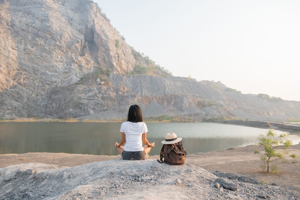 unita con la natura giovane donna che fa meditare all aperto vicino al lago